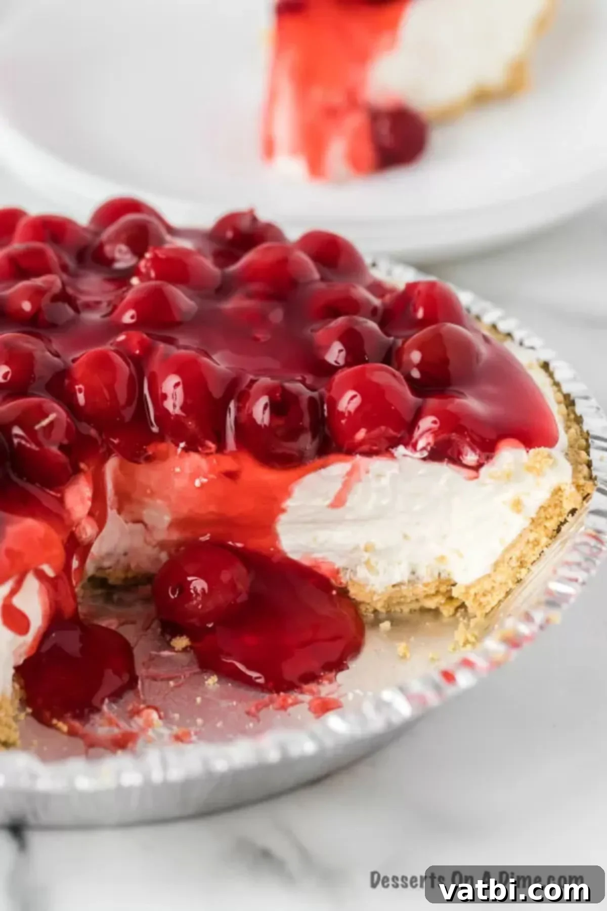 Effortless Philadelphia No-Bake Cheesecake 8 Close up image of Cheesecake topped with cherry pie filling