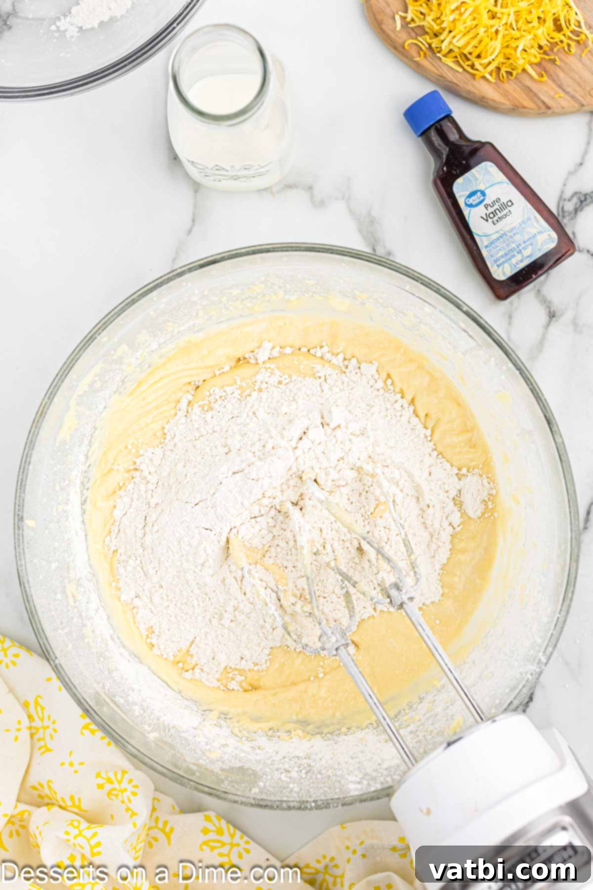 Sun-Kissed Lemon Cake Delight 6 Flour added to mixing bowl. Dry ingredients being gently mixed into the wet ingredients.