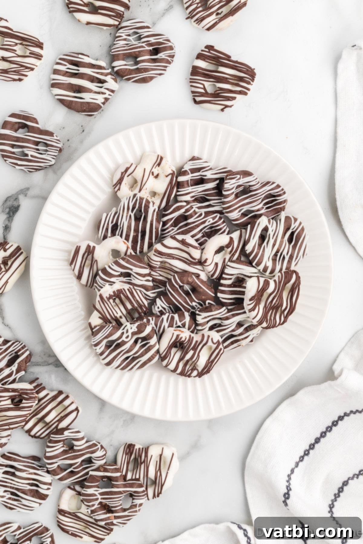 Sweet & Salty Pretzel Bliss 12 A festive plate showcasing a variety of chocolate covered pretzels, some with sprinkles and contrasting drizzles, making an appealing dessert display.
