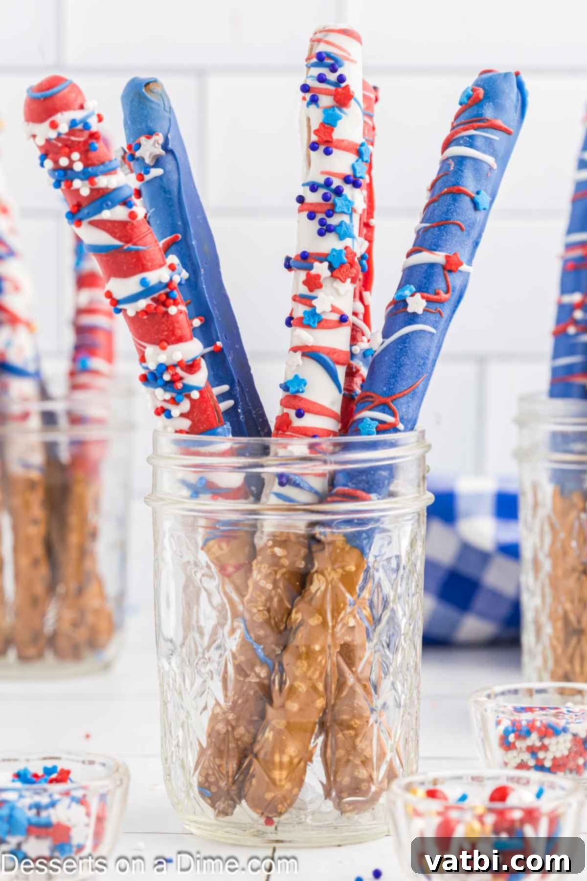 Make these easy 4th of July chocolate dipped pretzel rods for a red, white, and blue treat sure to impress. This recipe is simple yet looks amazing. Collection of festive red, white, and blue chocolate covered pretzel rods arranged on a tray, ready for a 4th of July celebration.