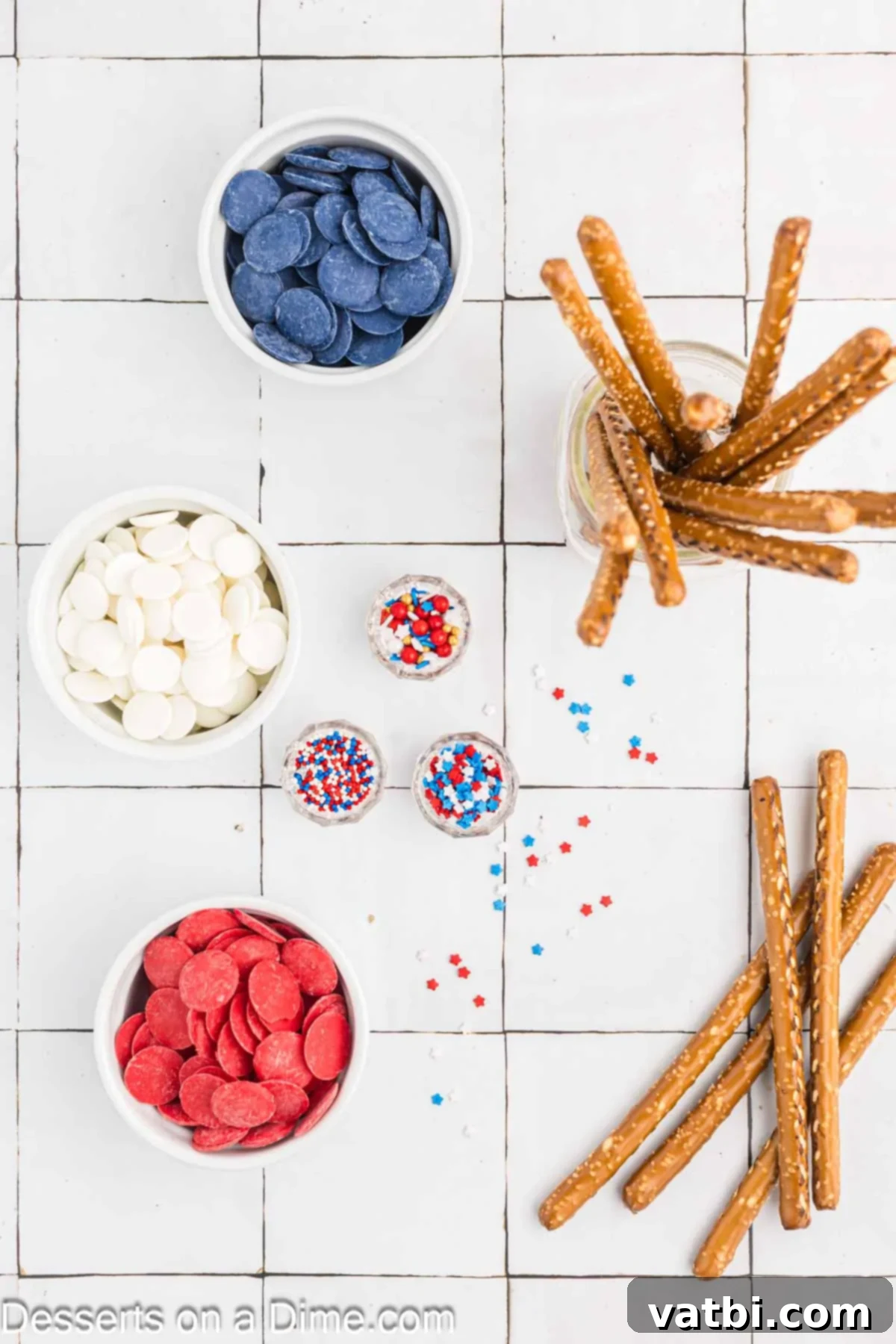 Make these 4th of July chocolate dipped pretzel rods for a red, white and blue treat sure to impress. This recipe is so easy but looks amazing. Close-up of key ingredients for chocolate covered pretzel rods: a bag of pretzel rods, red, white, and blue candy melts, and patriotic star sprinkles.