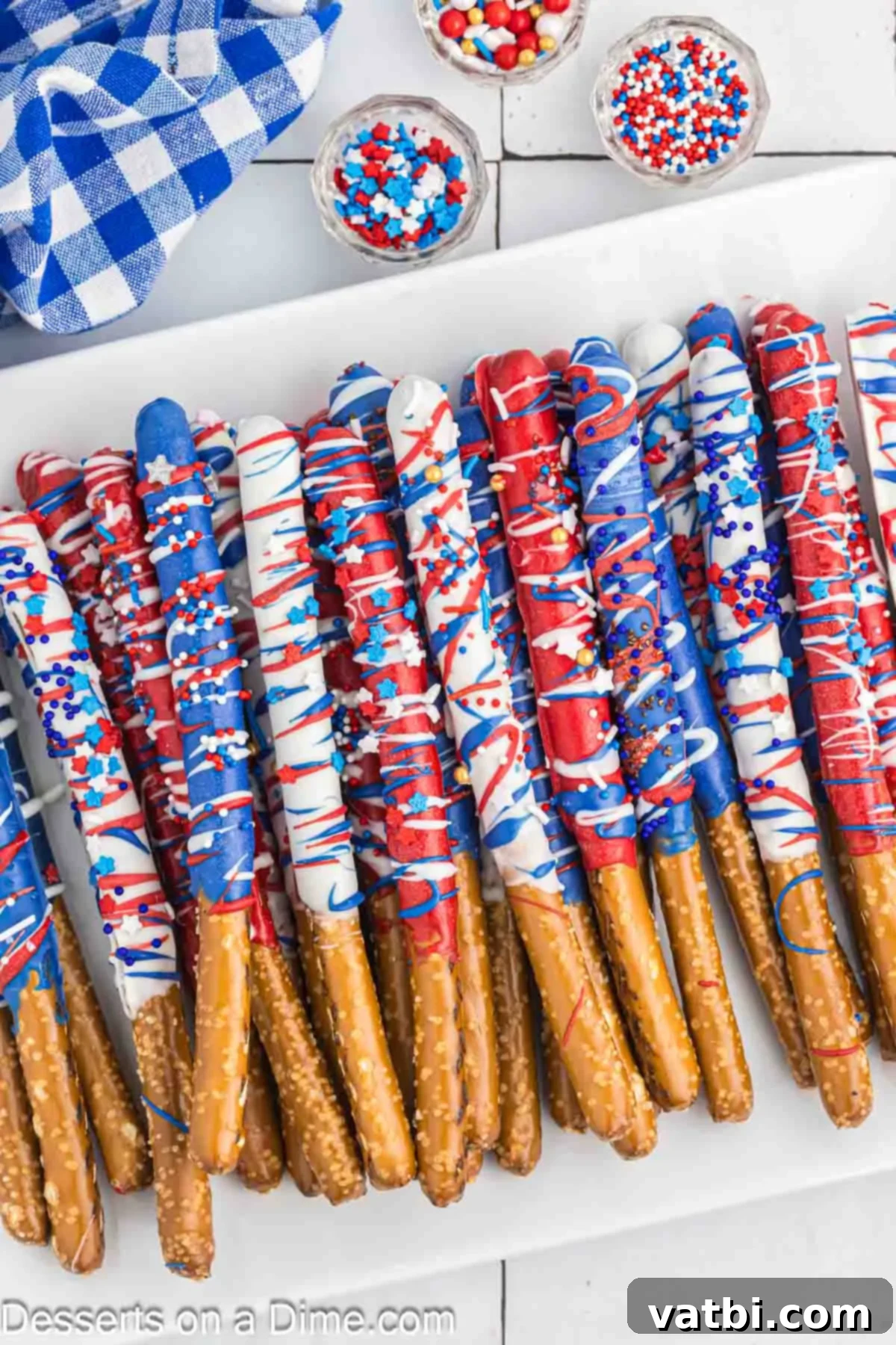 Make these 4th of July chocolate dipped pretzel rods for a red, white and blue treat sure to impress. This recipe is so easy but looks amazing. A festive display of a mason jar filled with various red, white, and blue chocolate covered pretzel rods, perfect for a patriotic celebration.