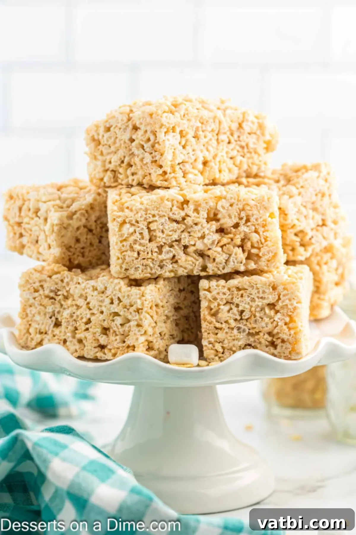 The Ultimate Rice Krispie Treat Recipe 13 Homemade Rice Krispie Treats on a platter, ready to be enjoyed.