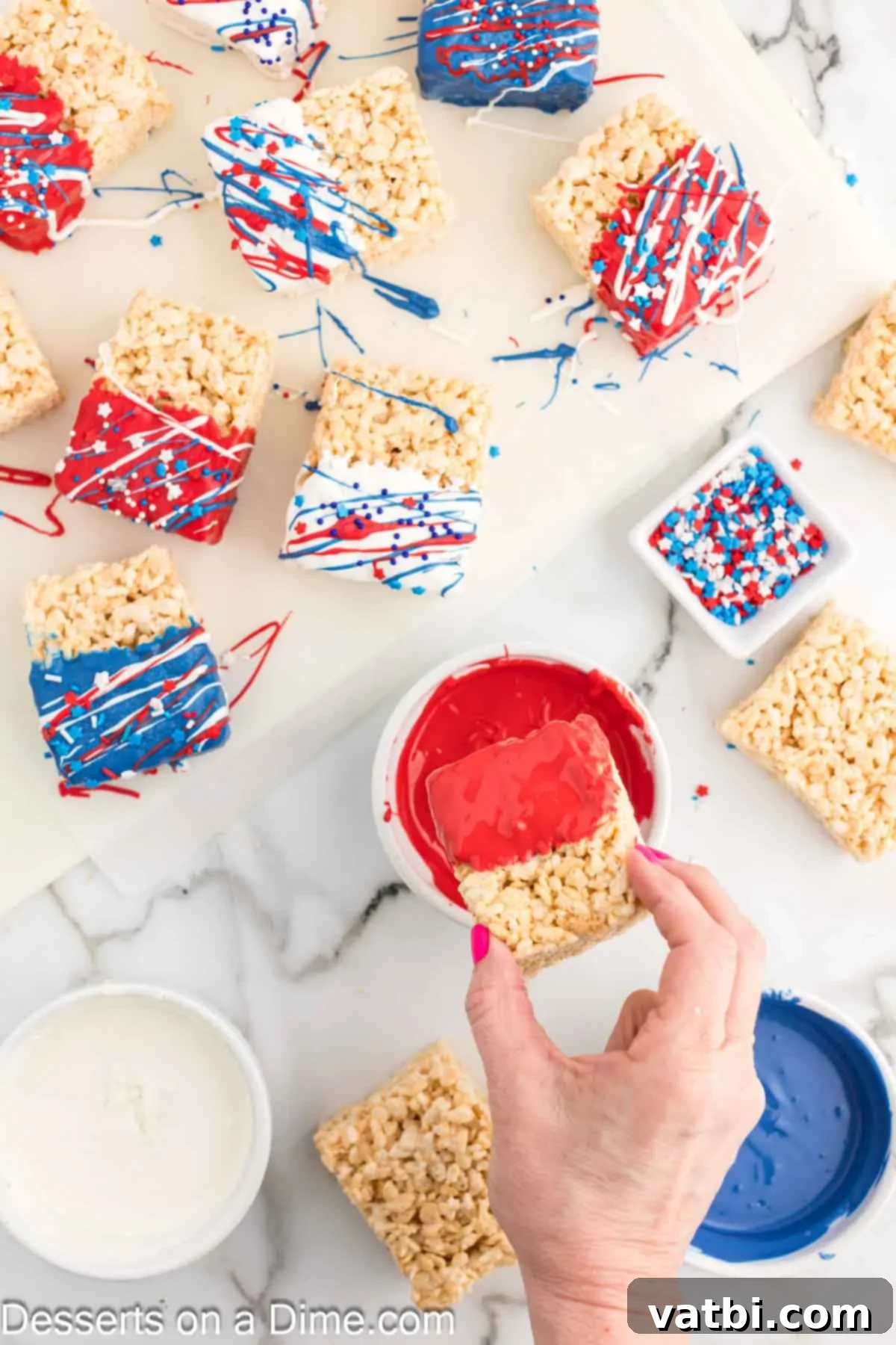 Patriotic Rice Krispie Delights 8 Rice Krispie Treats being dipped into separate bowls of melted red, white, and blue candy melts.