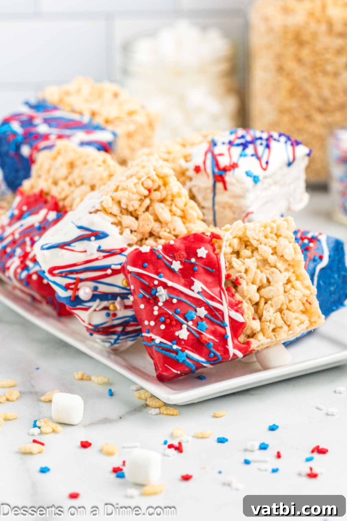 Patriotic Rice Krispie Delights 10 A festive platter of Red, White, and Blue Rice Krispie Treats decorated with star sprinkles, ready for a party.