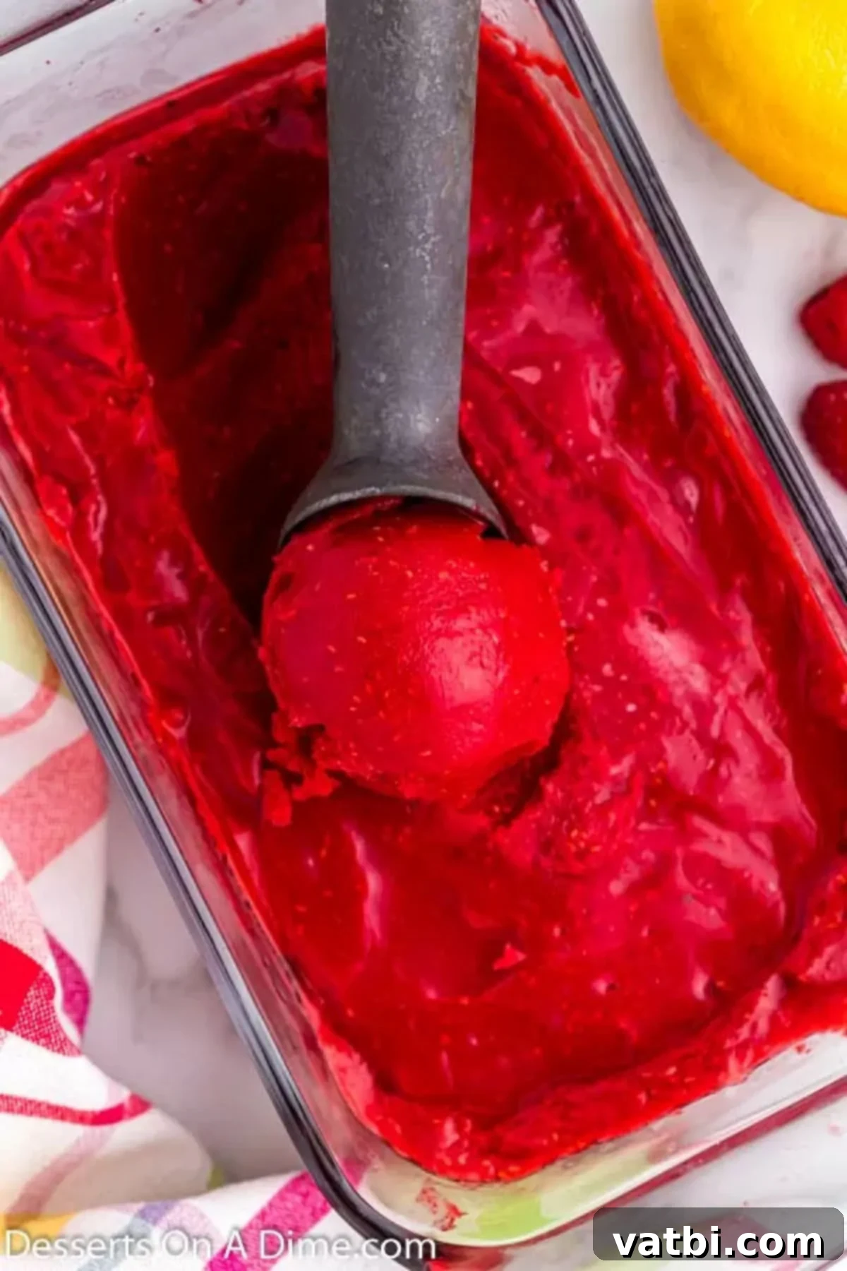 Pure Raspberry Bliss 6 Raspberry sorbet in a glass pan with an ice cream scoop