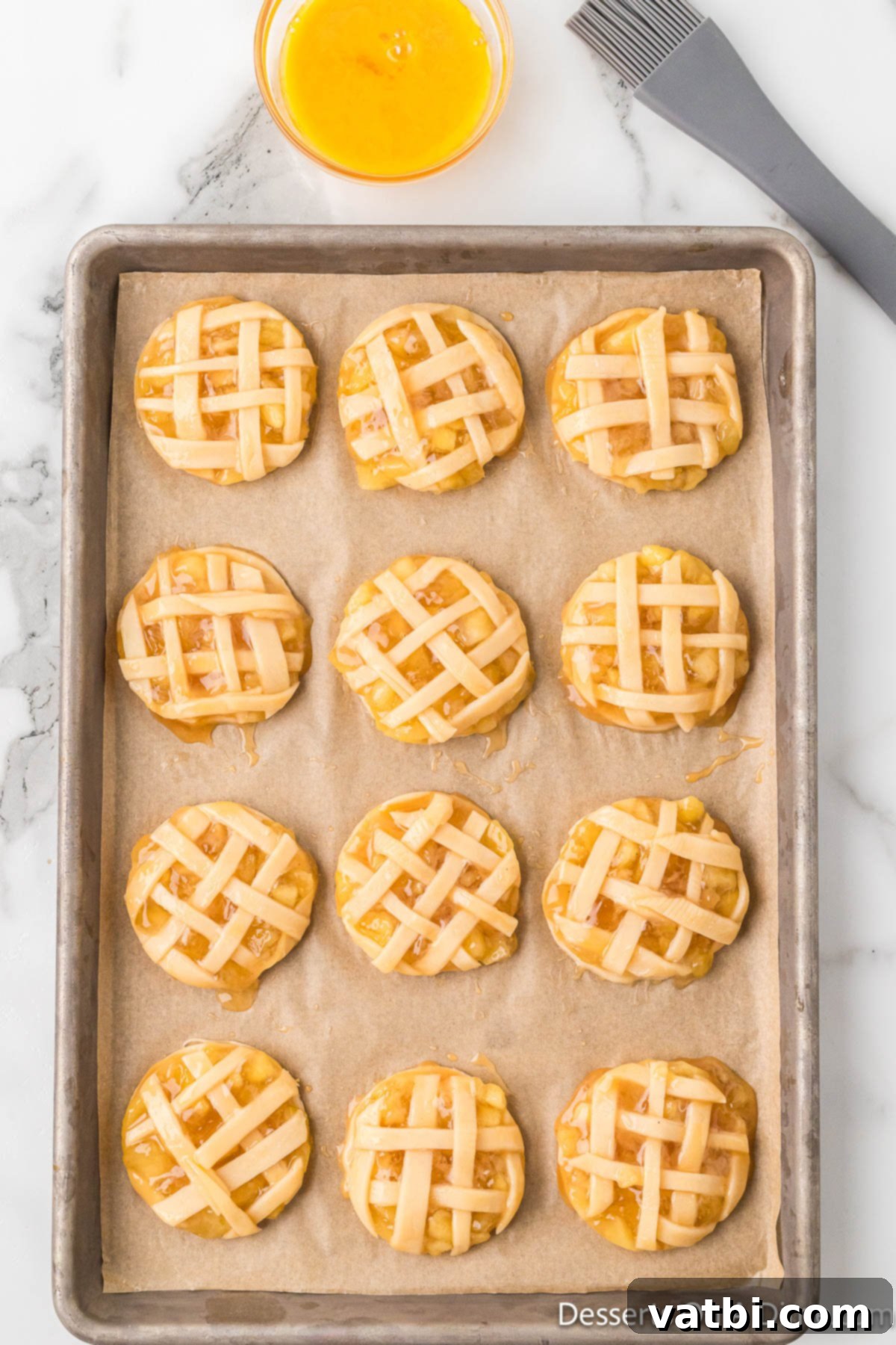 Apple Pie Stuffed Cookies 7 Round apple pie cookies cut out and arranged on a parchment-lined baking sheet.