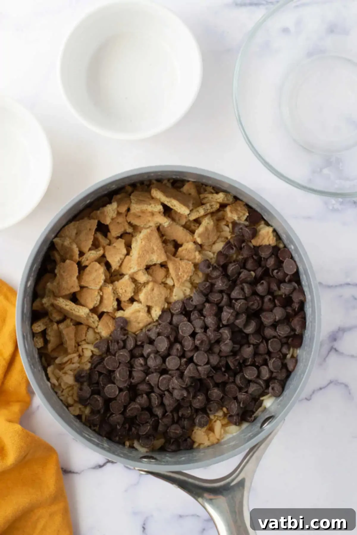 Campfire S'mores Rice Krispie Treats 5 Rice Krispie cereal, coarsely crumbled graham crackers, and semi-sweet chocolate chips being gently folded into the warm marshmallow mixture.