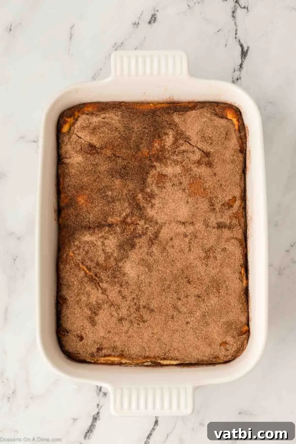 Cinnamon Sugar Cheesecake 13 The baked churro cheesecake bars, golden brown and cooling in the pan, waiting to be sliced and served.