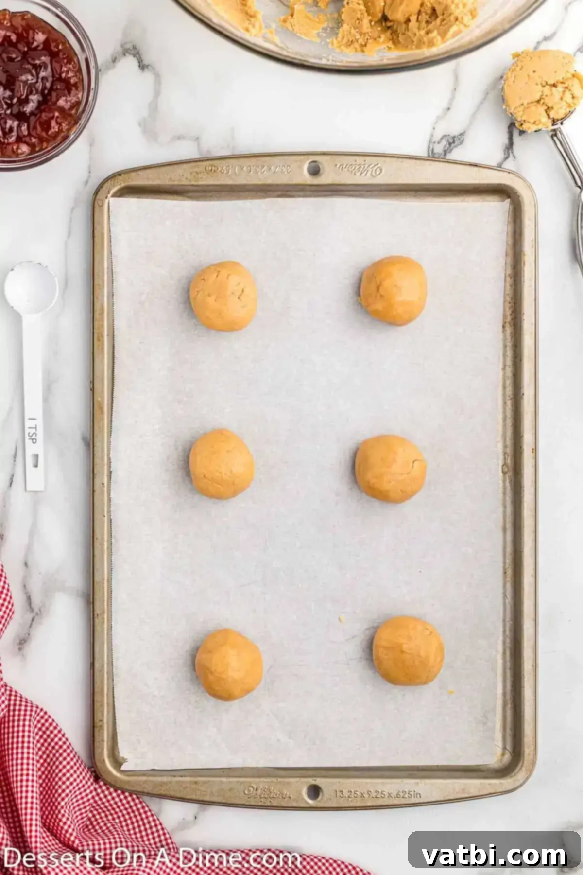 PB&J Cookie Perfection 7 Cookie dough balls neatly arranged on a baking sheet, ready for the next step.