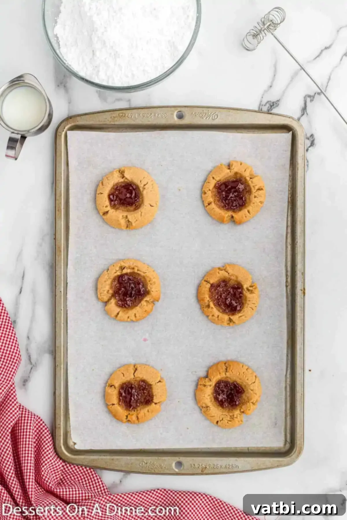 PB&J Cookie Perfection 10 Cookies baked and cooling on baking sheet, edges set and jam bubbling.