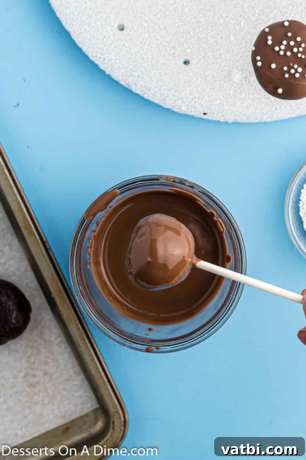 Bites of Brownie Bliss 9 A freshly dipped brownie cake pop, tilted to allow excess chocolate to drip off, ensuring a smooth finish.