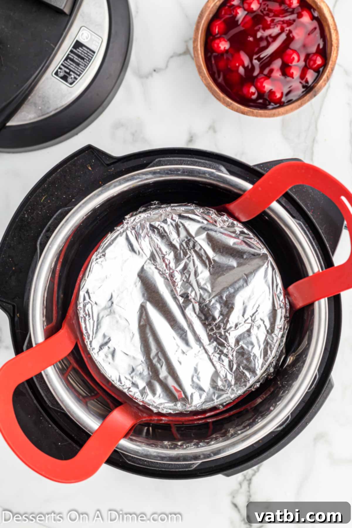 Instant Pot Cheesecake Perfection 7 Instant Pot setup with trivet, water, and foil-covered cheesecake pan inside.
