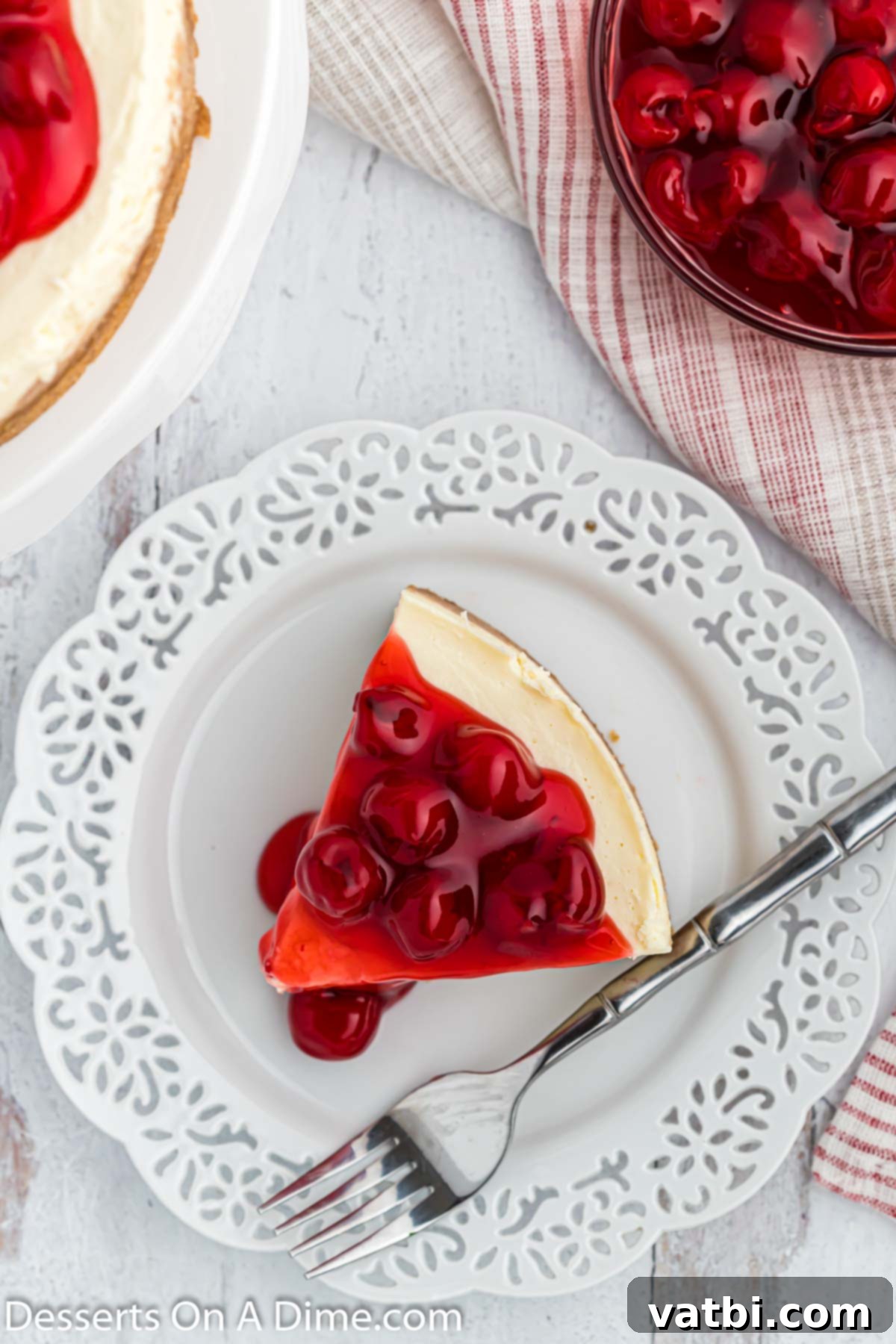 Instant Pot Cheesecake Perfection 10 A perfectly sliced Instant Pot cheesecake with cherry pie filling on a white plate, ready for dessert.