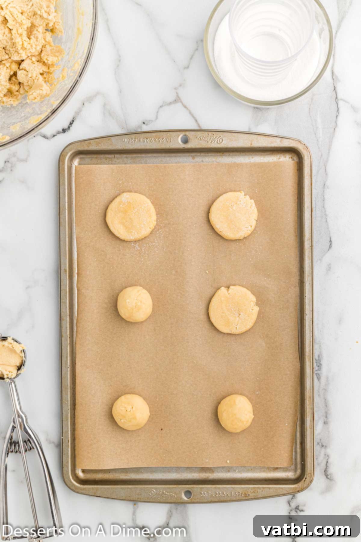 Homestyle Sugar Cookies 5 Scooped cookie dough balls arranged on a parchment-lined baking sheet.