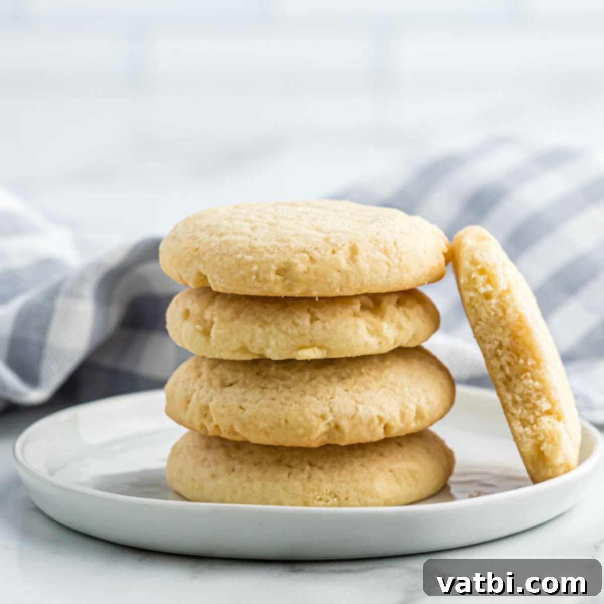 Homestyle Sugar Cookies 8 Stacked sugar cookies on a white plate, showcasing their soft texture.