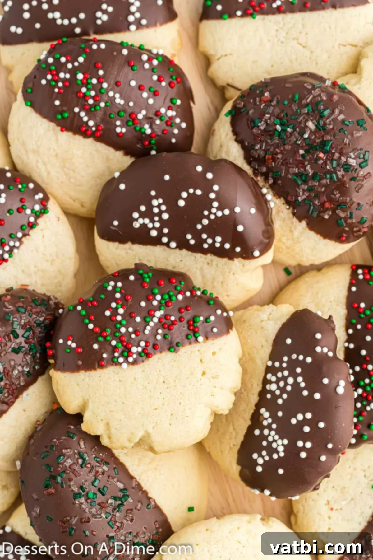 Irresistible Chocolate Dipped Sugar Cookies 2 A beautiful pile of chocolate dipped sugar cookies adorned with colorful sprinkles, showcasing their festive appeal.