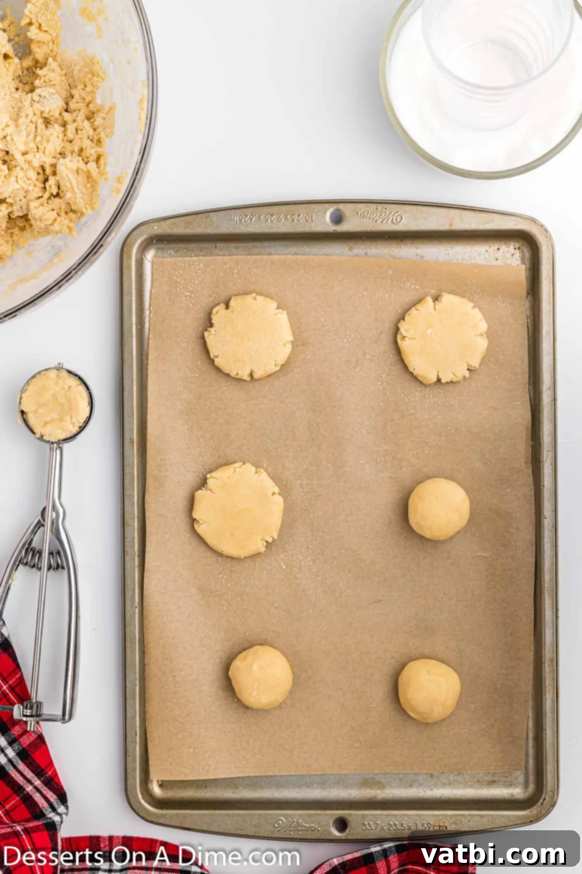 Irresistible Chocolate Dipped Sugar Cookies 6 Cookie dough scooped onto a lined baking sheet and flattened, ready for the oven.