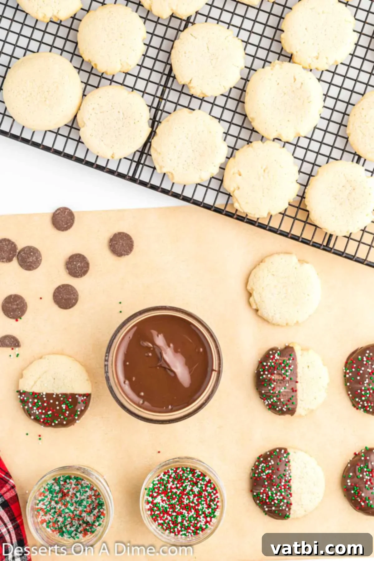 Irresistible Chocolate Dipped Sugar Cookies 9 Chocolate-dipped sugar cookies with sprinkles being placed on parchment paper to set.