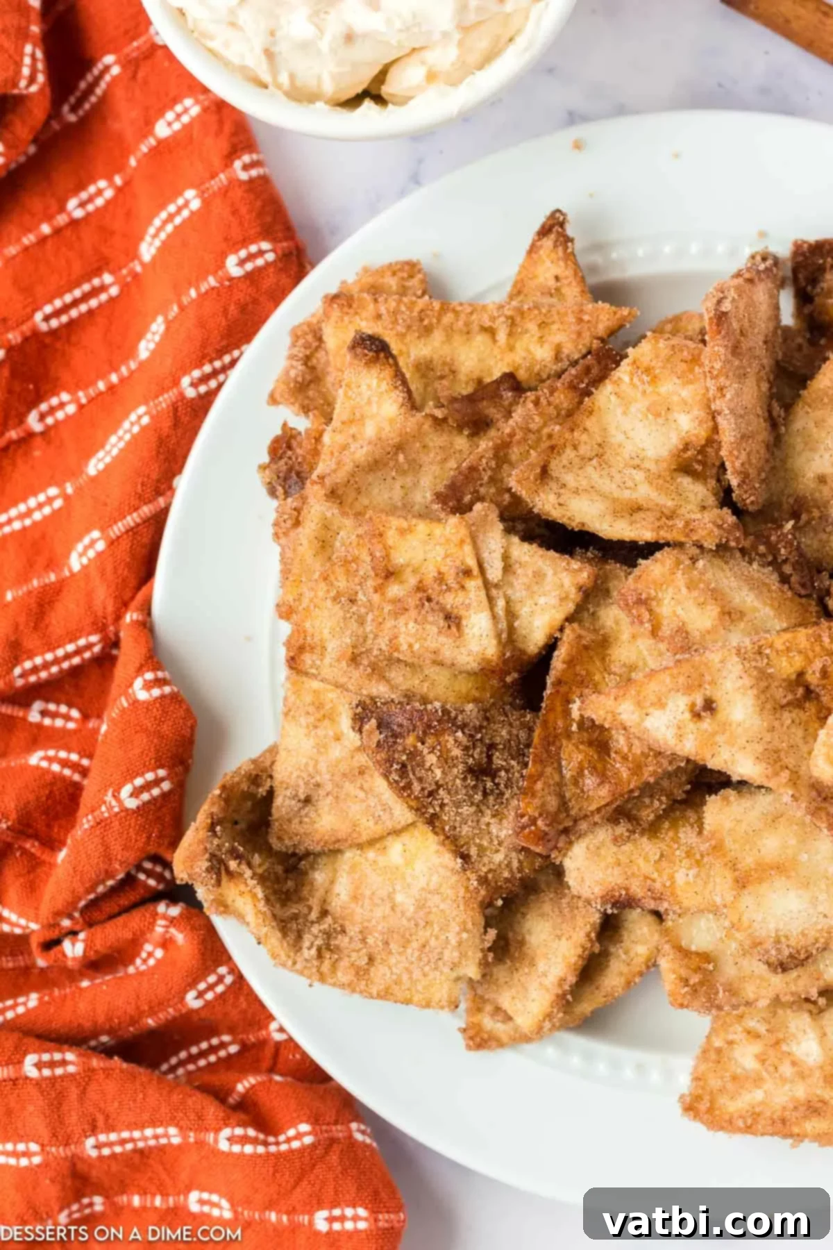 A close-up shot of crispy Air Fryer Churro Chips, generously sprinkled with cinnamon sugar, arranged artfully on a serving platter.

