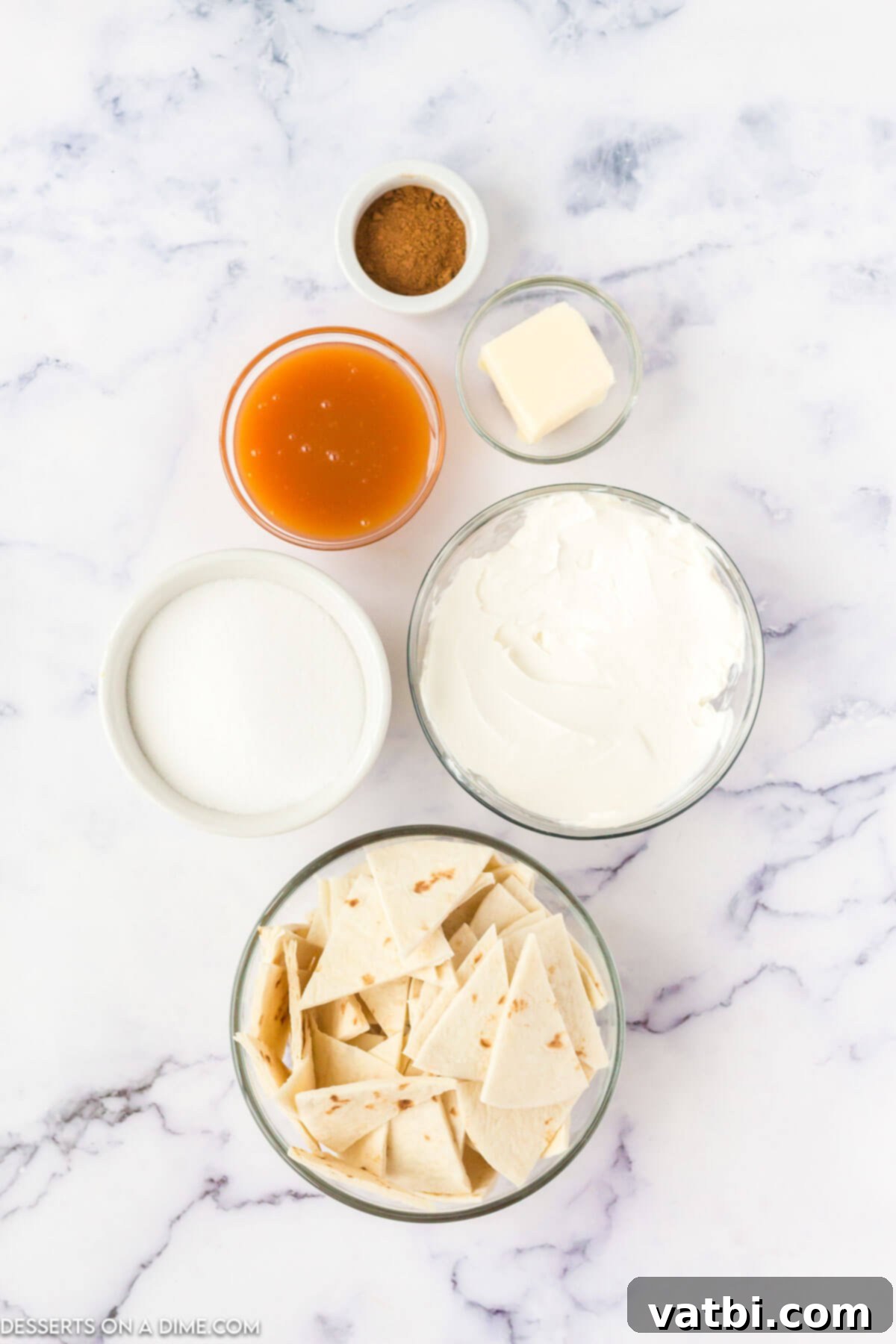 A flat lay photograph showcasing all the simple ingredients required to make Air Fryer Churro Chips, including tortillas, butter, sugar, and cinnamon.
