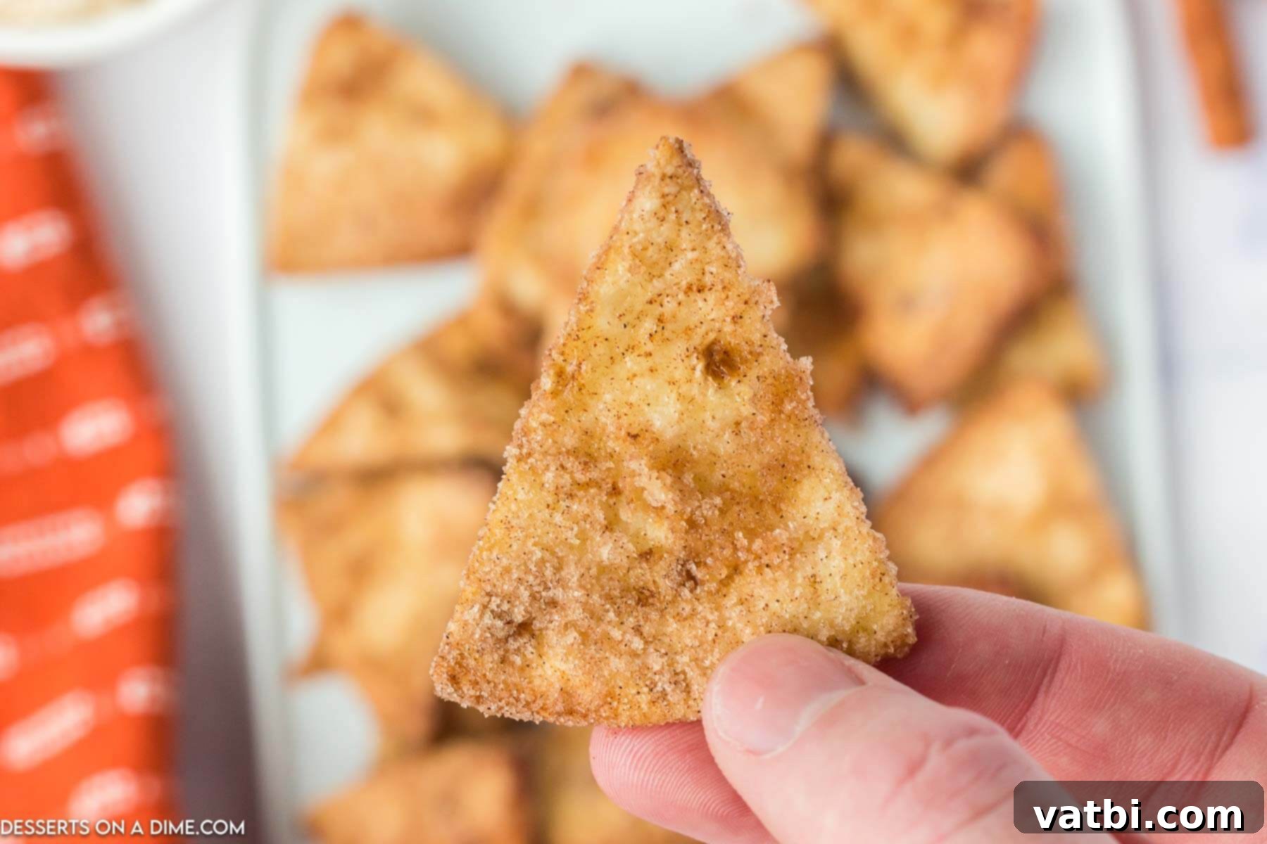 An inviting close-up of a stack of Air Fryer Churro Chips, showcasing their golden crispiness and generous cinnamon sugar coating.
