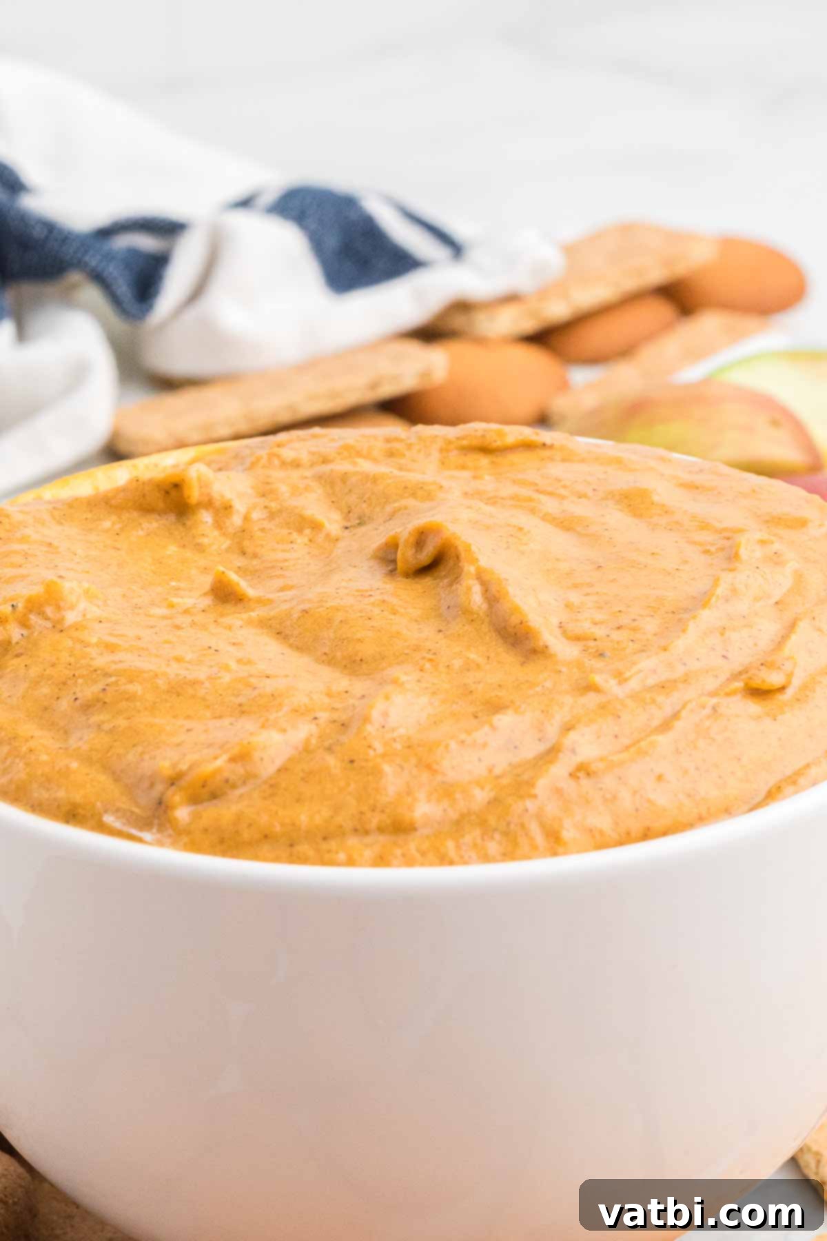 Delicious Pumpkin Dip 8 Pumpkin dip in a white bowl with a gingersnap cookie and fresh fruit on the side
