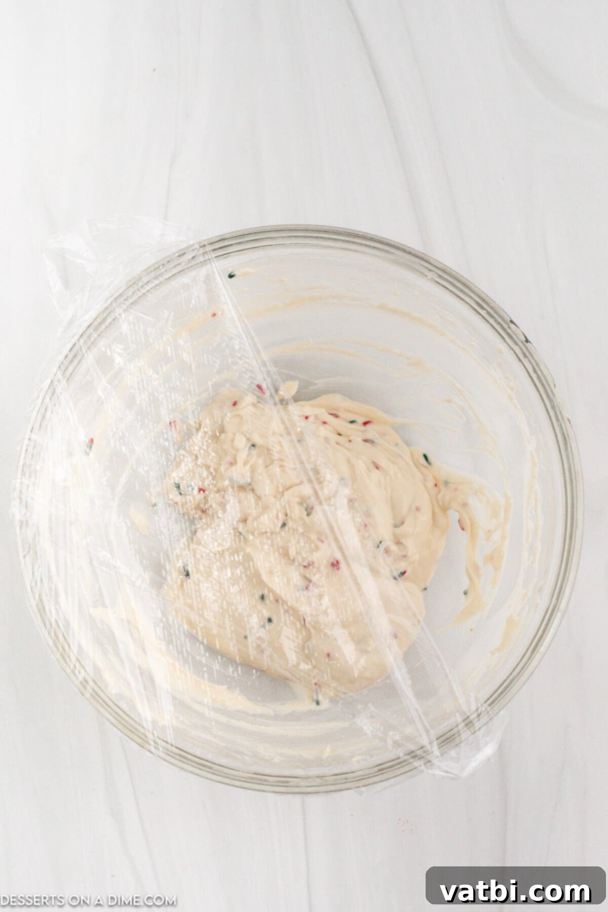 Santa's Favorite Cookie Dip 6 Step 3: Gently folding in holiday sprinkles into the Christmas cookie dip mixture, reserving some for topping.