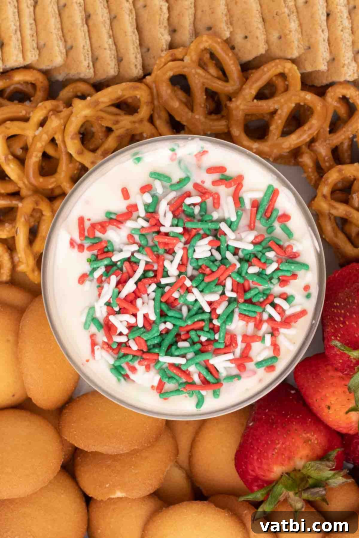 Santa's Favorite Cookie Dip 7 Step 4: The finished Christmas cookie dip in a serving bowl, topped with extra sprinkles and surrounded by dippers.