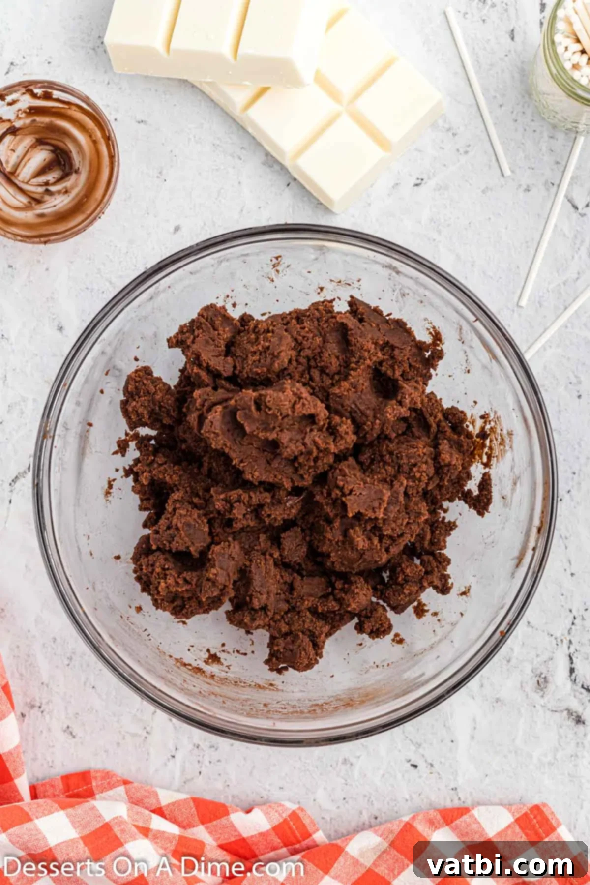 Chocolate cake crumbs thoroughly mixed with chocolate fudge frosting in a bowl, forming a pliable cake pop dough.