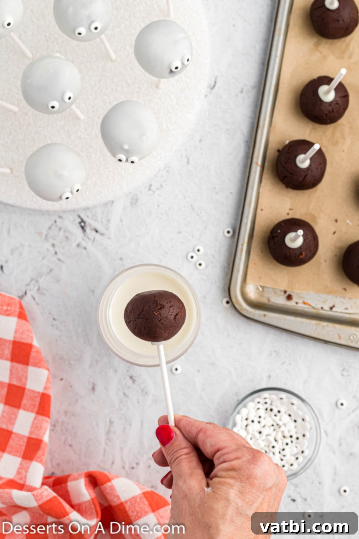 A cake pop being dipped into melted white almond bark, ensuring a smooth and even coating.