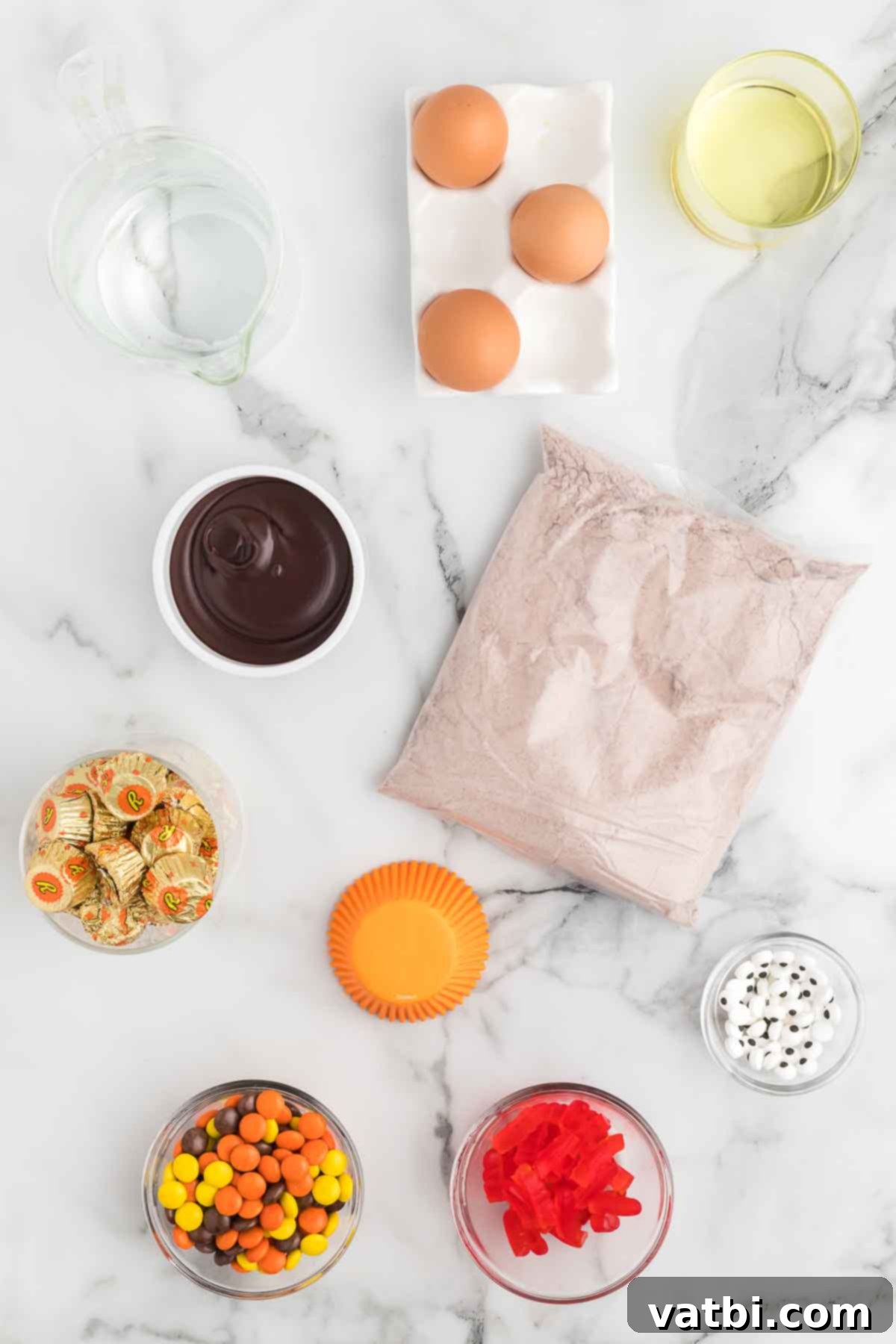Ingredients for Turkey cupcakes - chocolate cake mix, orange cupcake liners, chocolate frosting, reese's peanut butter cups, candy eyes, reese's pieces. 