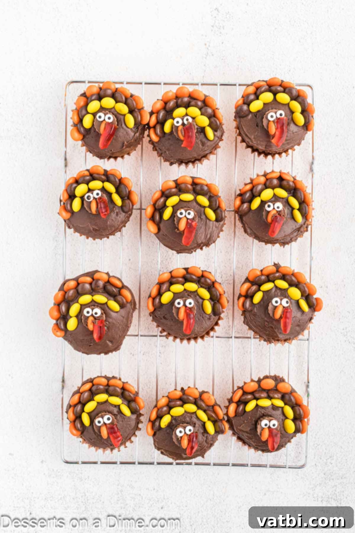 Cupcakes with gummy worms placed on top. 
