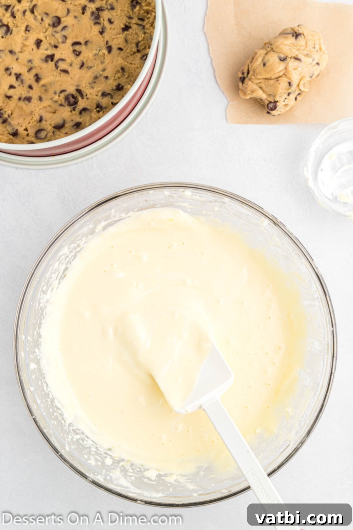 Chocolate Chip Cookie Cheesecake 6 Sour cream being gently folded into the cheesecake batter, creating a smooth mixture.