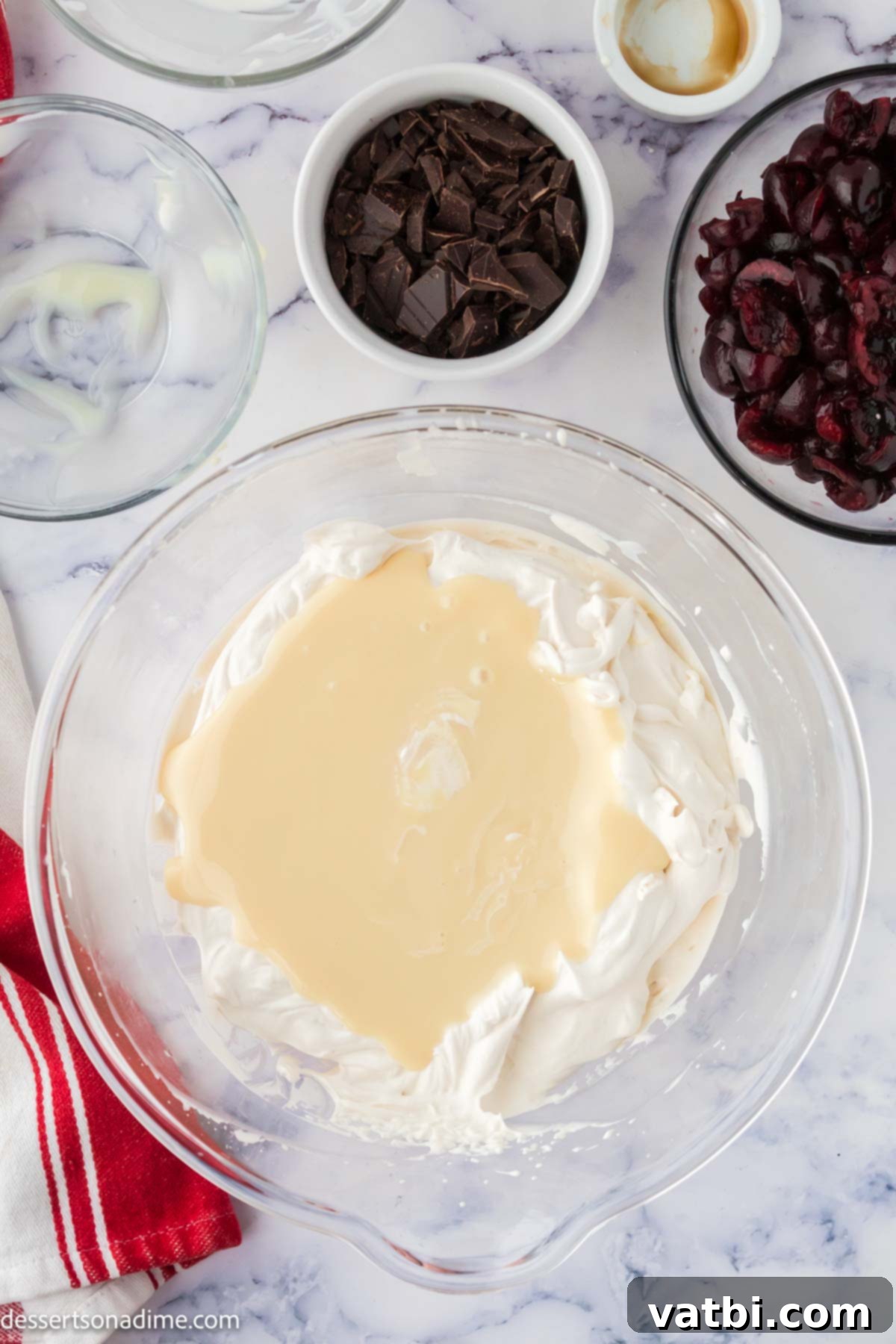 Homemade Cherry Garcia Ice Cream 4 Mixing bowl with sweetened condensed milk and whipped cream being gently folded together.