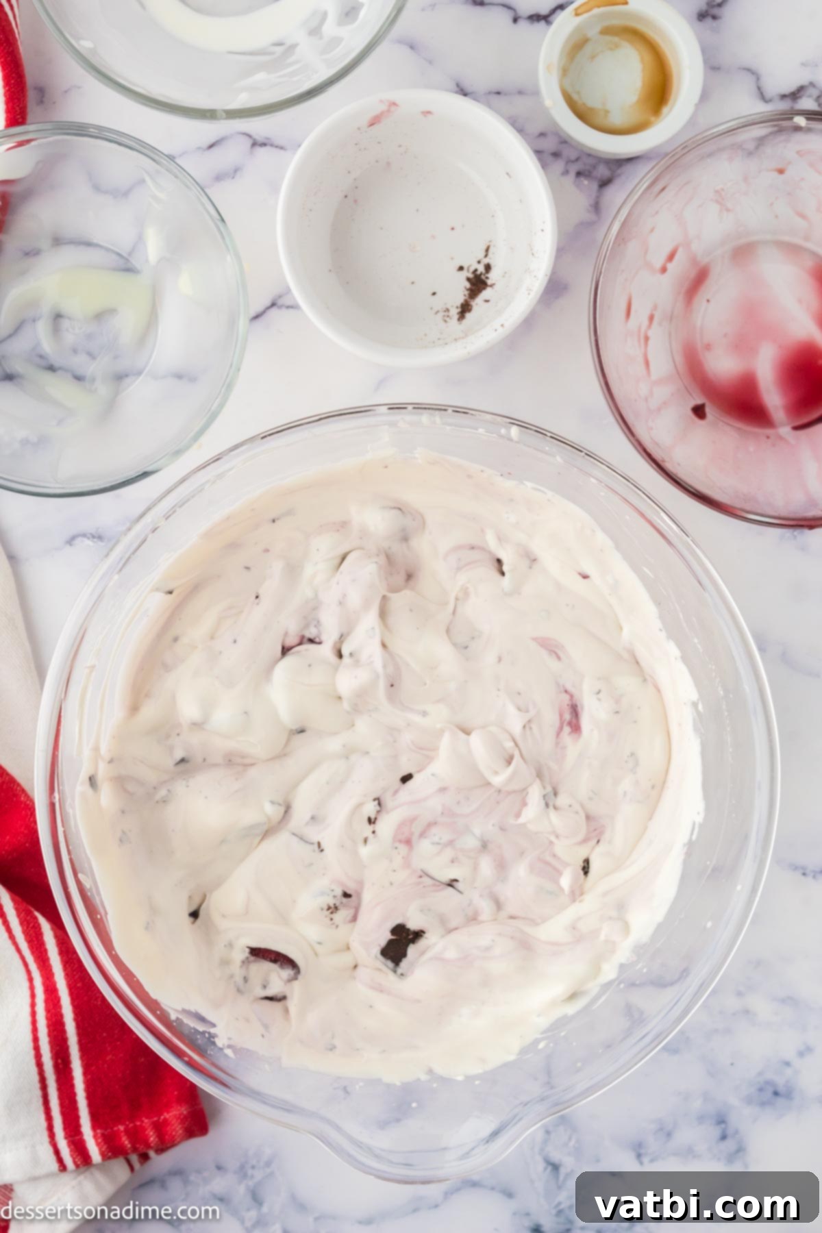 Homemade Cherry Garcia Ice Cream 5 Chopped fresh cherries and dark chocolate chunks being folded into the ice cream mixture.