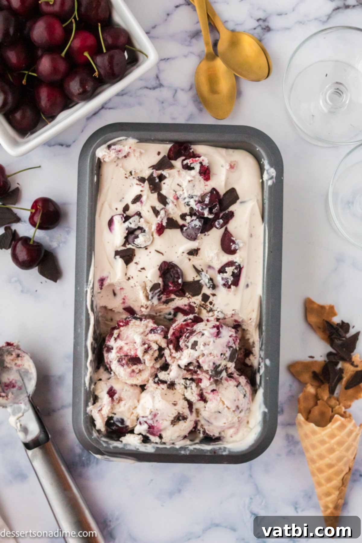 Homemade Cherry Garcia Ice Cream 7 Close-up of Cherry Garcia ice cream mixture in a loaf pan, topped with cherries and chocolate, ready for freezing.