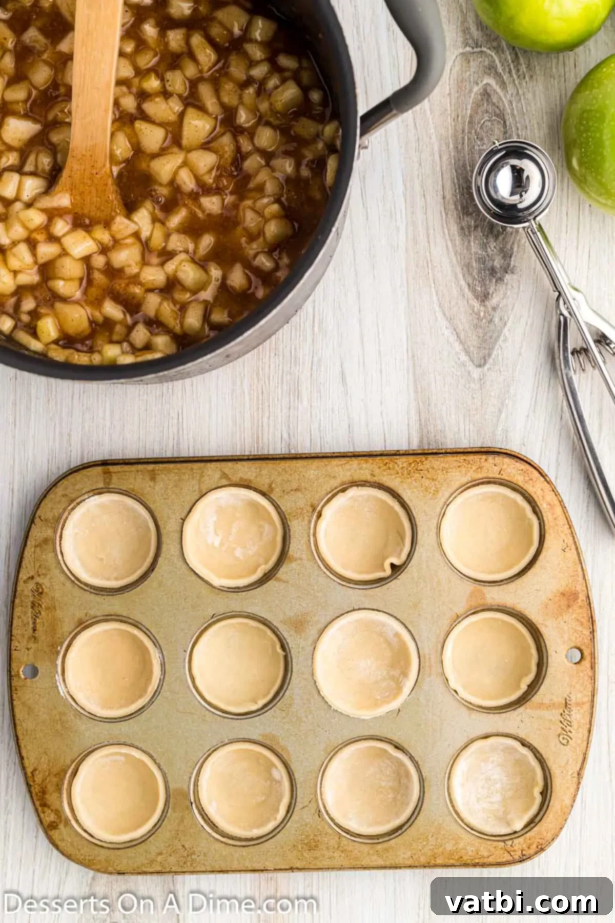 Apple Pie Poppers 9 Pie dough circles pressed into mini muffin tins, forming small cups.