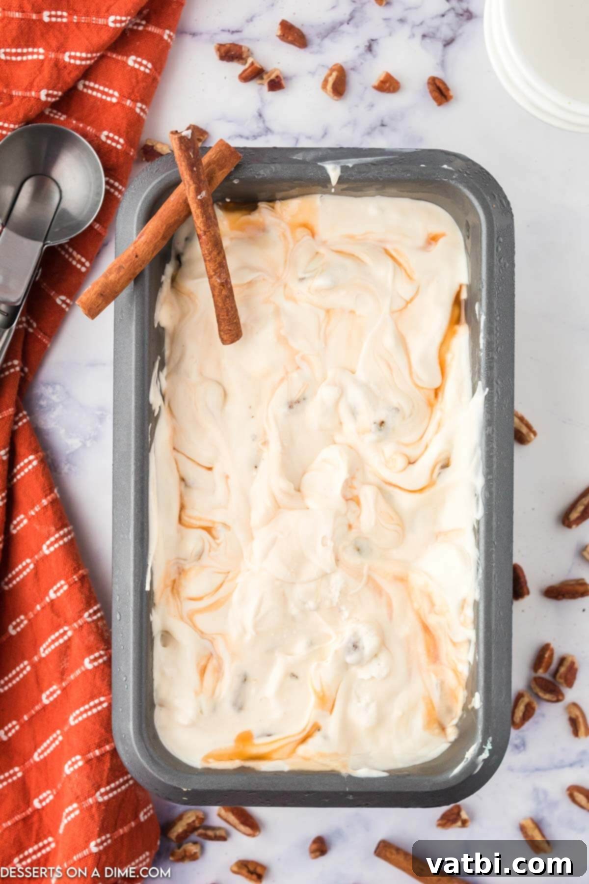 Caramel Pecan Praline Ice Cream beautifully spread in a metal loaf pan, ready to be scooped.