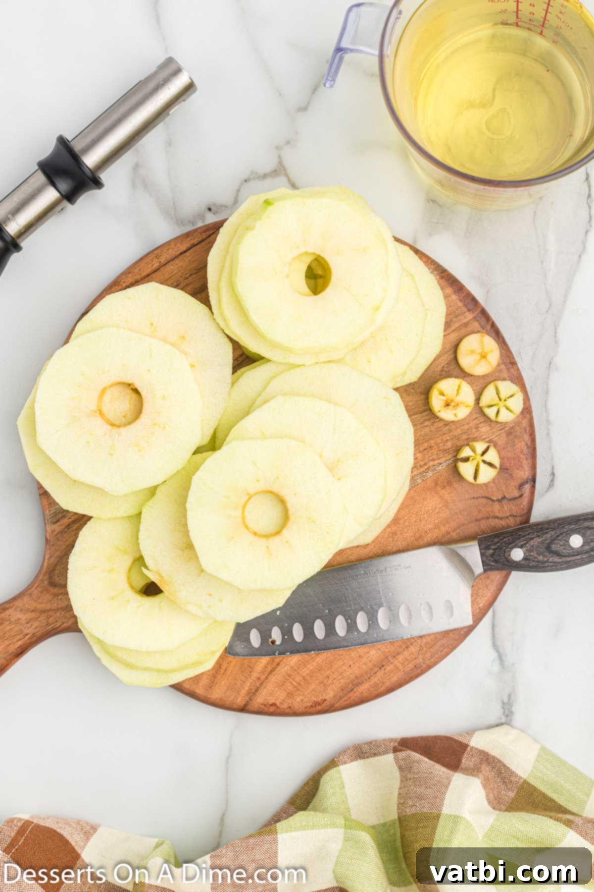 Golden Apple Fritters 4 Apple slices on cutting board, ready for preparation.