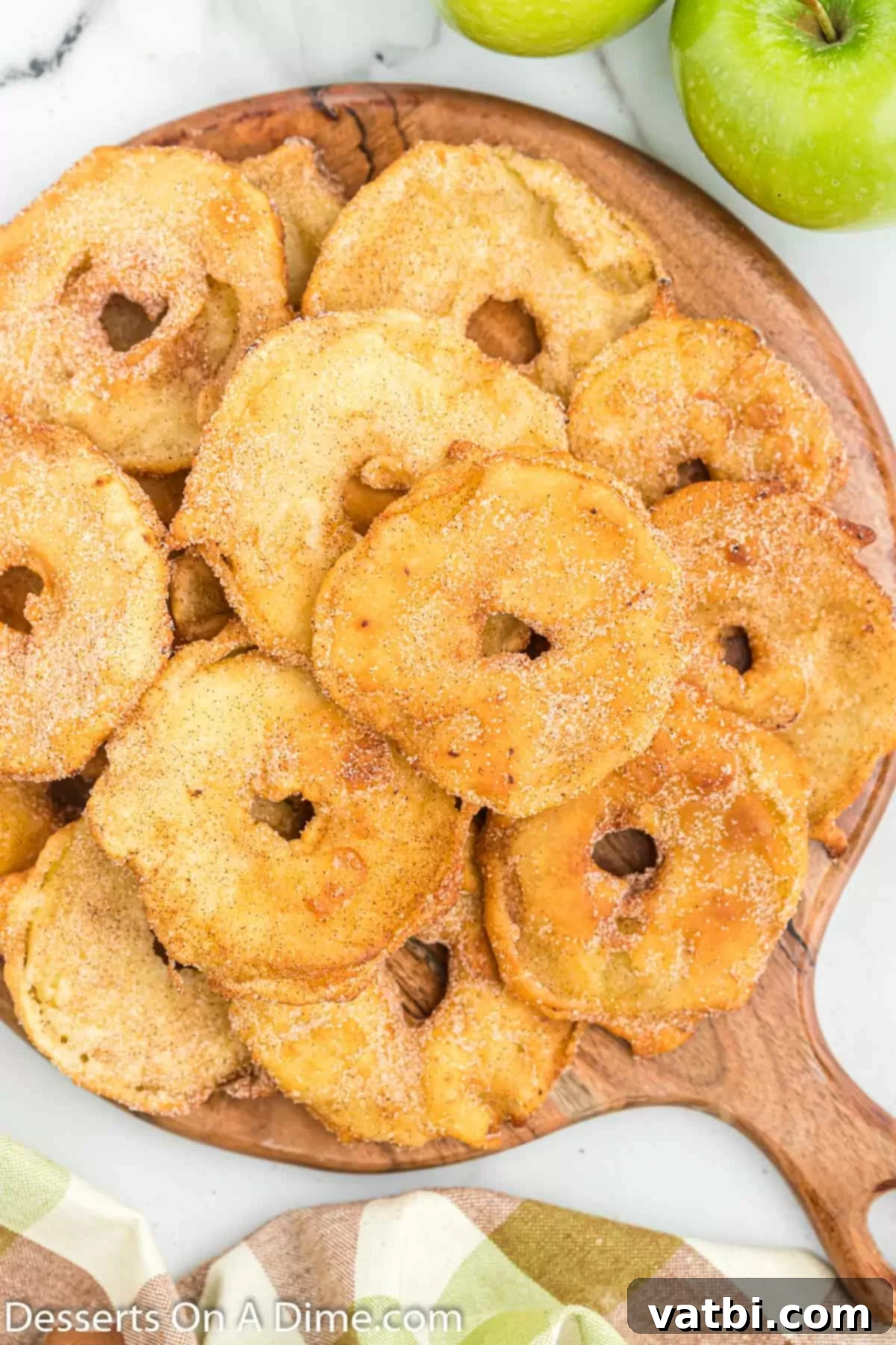 Golden Apple Fritters 8 Fried Apple Slices stacked on a brown platter, ready to be served.