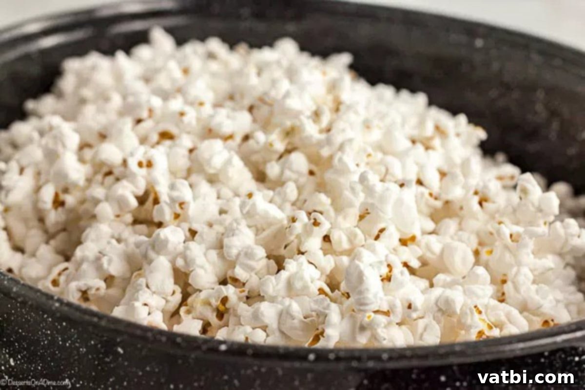 Golden Popcorn Delights 2 Popped popcorn in a large roasting pan, ready for the syrup.