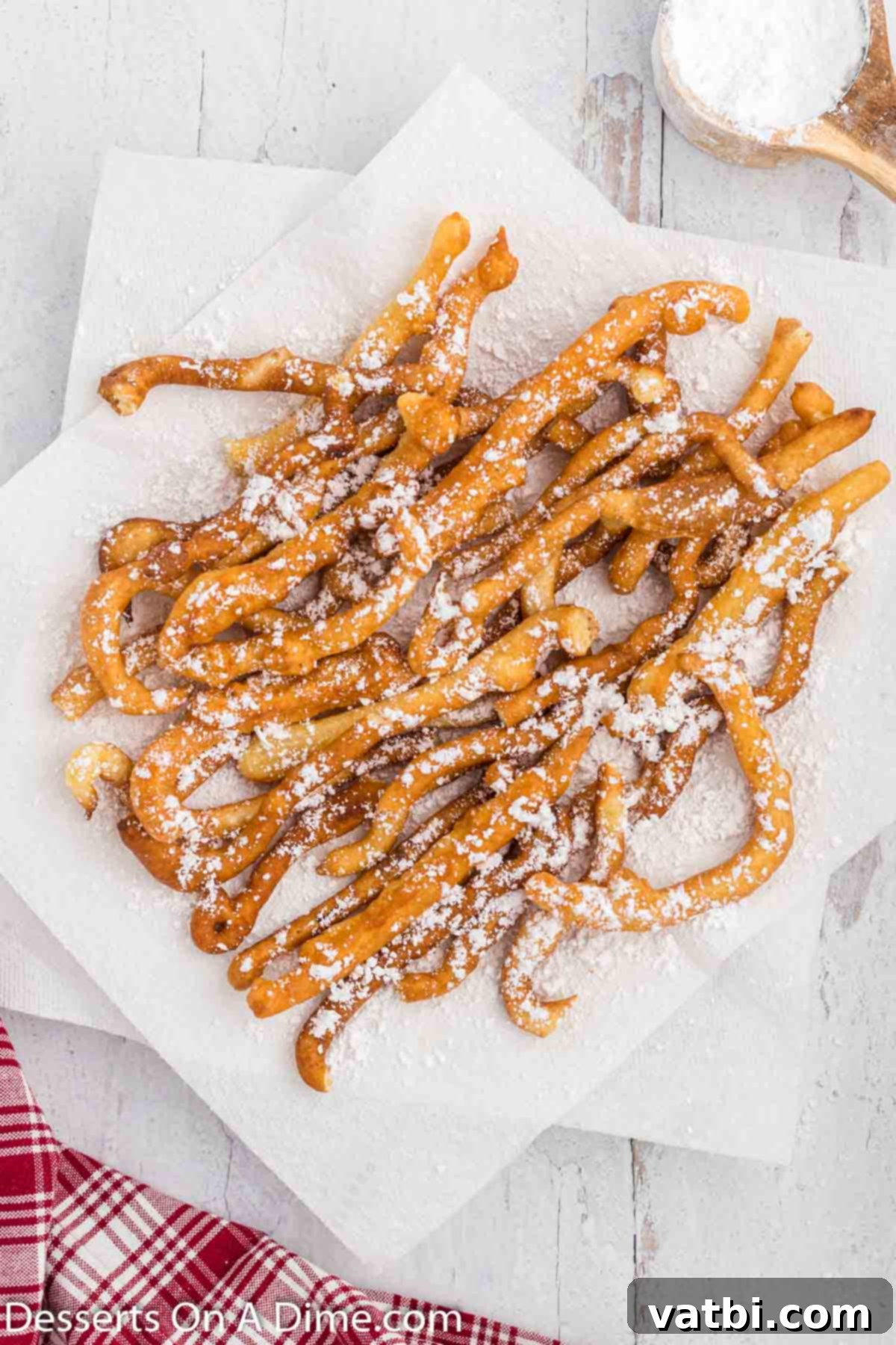 Crispy Funnel Sticks 8 Funnel cake fries on plate and topped with powdered sugar.