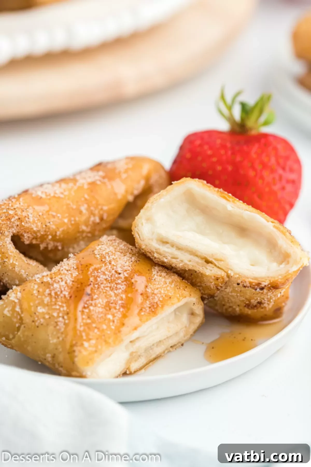 Crispy Cheesecake Dessert Chimis 10 Cheesecake chimichangas cut in half on a platter.