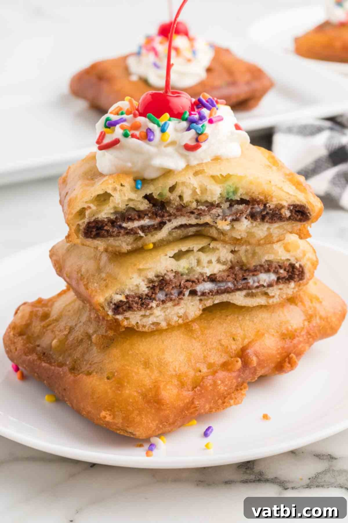 Golden Crisp Pop Tart Heaven 10 Close-up of a plate of deep fried pop tarts topped with whipped cream, sprinkles, and a cherry, ready to be eaten.