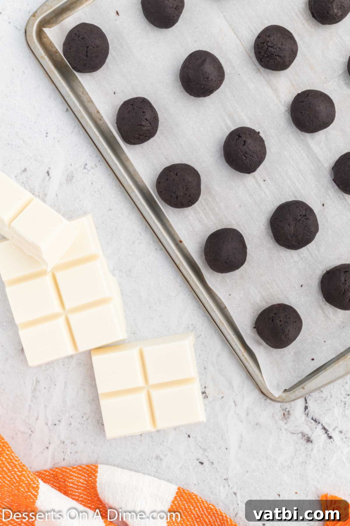 Whimsical Winter Oreo Bites 6 Formed Oreo balls placed on a parchment-lined baking sheet, ready for freezing.