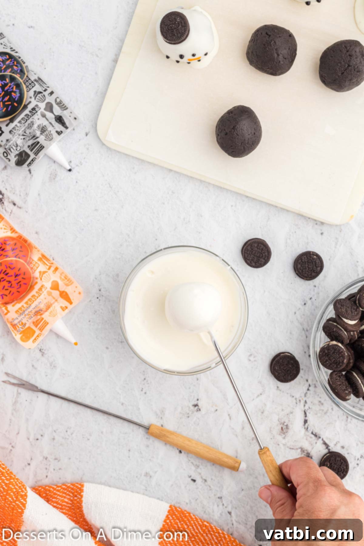 Whimsical Winter Oreo Bites 8 A freshly dipped Oreo ball with excess white chocolate dripping off.