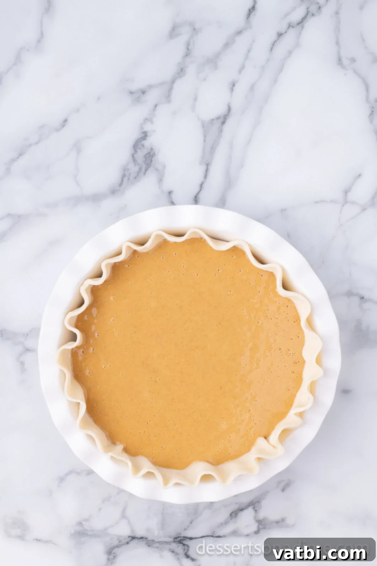 Dulce De Leche Swirl Pumpkin Pie 5 The smooth Dulce De Leche pie mixture expertly poured into the chilled pie crust, ready for baking.