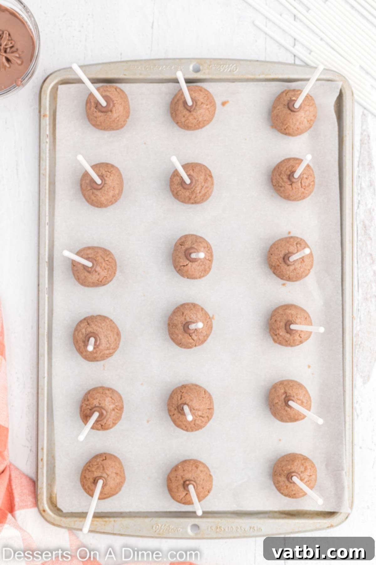 Gobble-Worthy Thanksgiving Cake Pops 7 Cake Pop sticks inserted into balls on baking sheet.