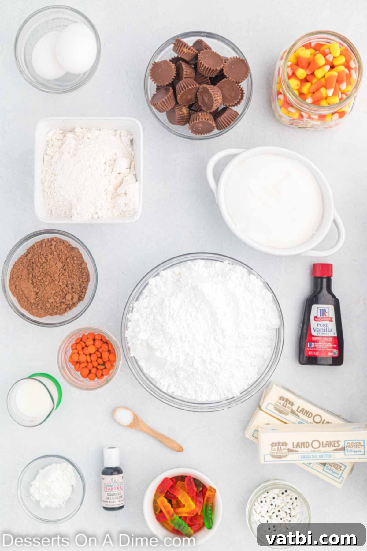 Ingredients for Thanksgiving sugar cookies - flour, butter, egg, egg yolk, vanilla, powdered sugar, cocoa powder, milk, mini reese's cups, candy eyes, gummy worms, candy corn. mini orange M&M's. 